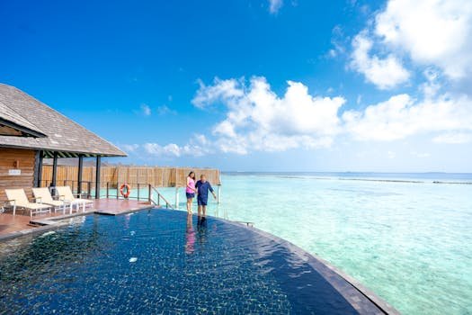 Couple enjoying a tropical beach resort with infinity pool and ocean view.